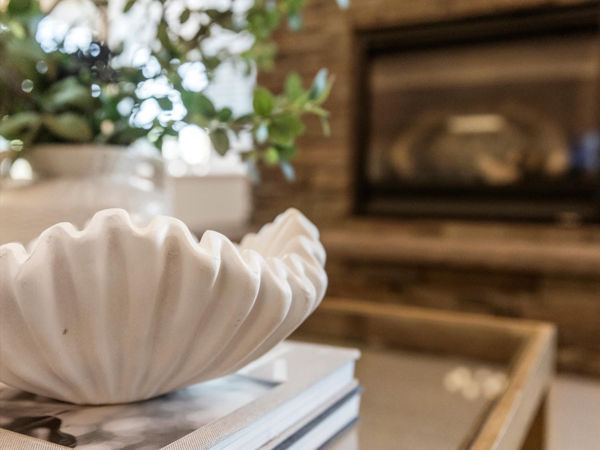Decorative ceramic bowl on a table with the great room fireplace in the background